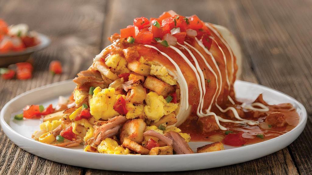 Smothered Breakfast Burrito* · Choice of roasted chicken breast or smoked pork carnitas with country potatoes, scrambled eggs, cheese, onion, tomato, corn and jalapeños. Topped with pork green chili, sour cream and fresh pico de gallo. Hash browns and bread choice not included..