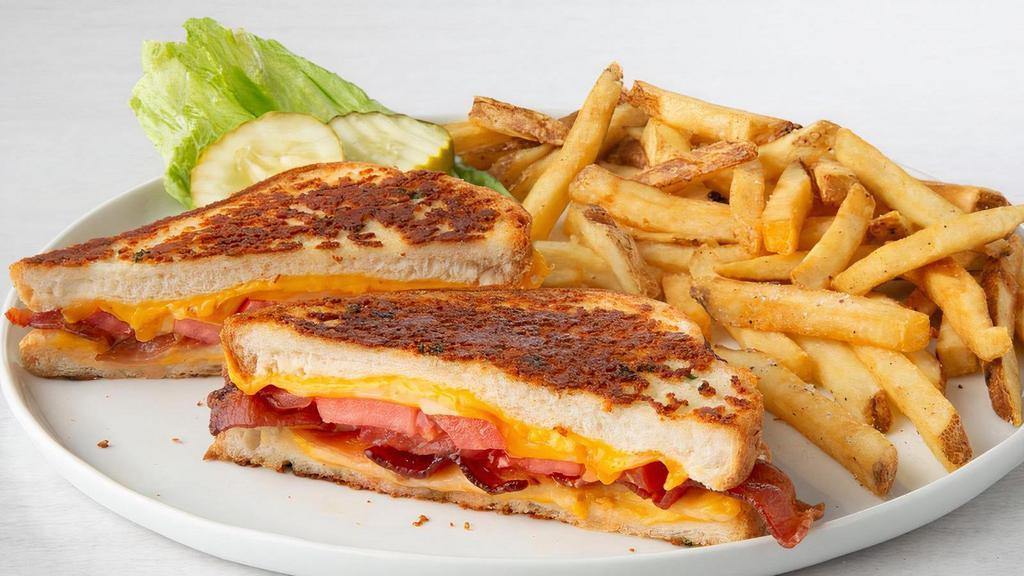 Grown-Up Grilled Cheese · American, Cheddar, Monterey Jack and Mozzarella cheeses, bacon and grilled tomato slices on Parmesan-crusted bread..