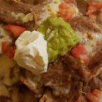 Mexican Nachos · Fried tortilla chips topped with cheese sauce, beans, garnished with lettuce pico de gallo, ...