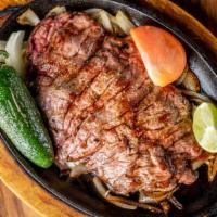 Carne Asada · Seasoned certified Angus Beef steak with grilled onions, served with rice, beans, lettuce, g...