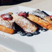 French Toast With Berries · Brioche soaked in egg, pan seared, topped with sugar and fresh fruit.
