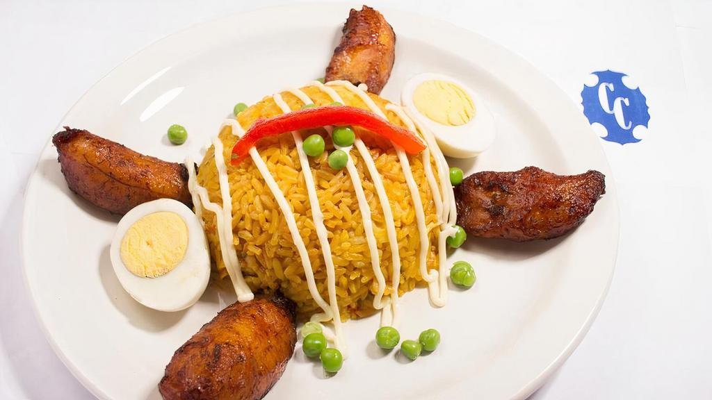 Arroz Imperial · Boneless Chicken and Yellow Rice, Topped with Mayonnaise or Cheese, Pimiento, Green Peas and a Hard Boiled Egg, Served with Maduros