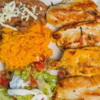 Pollo A La Plancha · Grilled chicken breast served with a side of yellow rice and refried beans or house salad.
