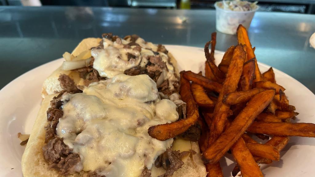 Philly Cheese-Steak · Shaved ribeye steak with grilled onions, sautéed mushrooms, and melted provolone cheese served on a toasted hoagie roll.