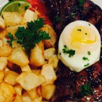 Bitoque Bife · NY strip topped with fried egg, rice and fried potatoes.