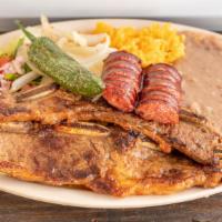 Costillitas · 2 grilled short ribs with spicy sausage served with rice beans, salad & 4 tortillas. Comes w...