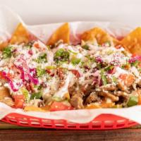 Nachos Lokos · Tortilla chips loaded with mozzarella, sour cream, pico, pink  cabbage, cotija and your choi...
