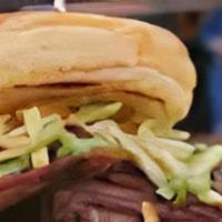 Brisket Sandwich · Smoked brisket on a French bread topped with BBQ, green sauce, and potato sticks. Served wit...