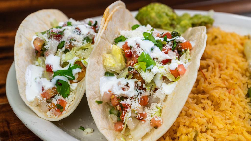 Fish Or Shrimp Tacos · Two corn or flour tortilla tacos filled with fish or diced shrimp. Topped with lettuce, Pico de Gallo, cilantro, cotija cheese, crema Mexicana and served with guacamole.