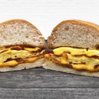 Signature Breakfast Sandwich · Scrambled Eggs and All-Natural Bacon folded together with Swiss Cheese on a Grilled Kaiser R...