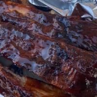 Ky Smoked Ribs  · 3 bones of smoked dry rubbed ribs top with Ali barbecue sauce. Served with 2 sides.