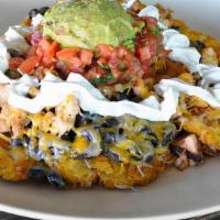 Tostones Fiesta · Fried plantain topped with beans, cheese, your choice of meat, pico de gallo, guacamole & so...
