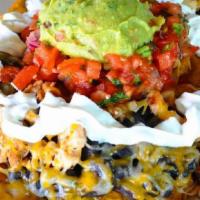 Tostones Fiesta · Fried plantain topped with beans, cheese, your choice of meat, pico de gallo, guacamole & so...