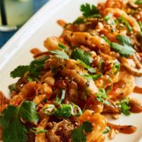 Shanghai Flash-Fried Calamari · ginger-chili and Thai peanut sauces, scallions, pickled jalapeños, cilantro, peanuts.