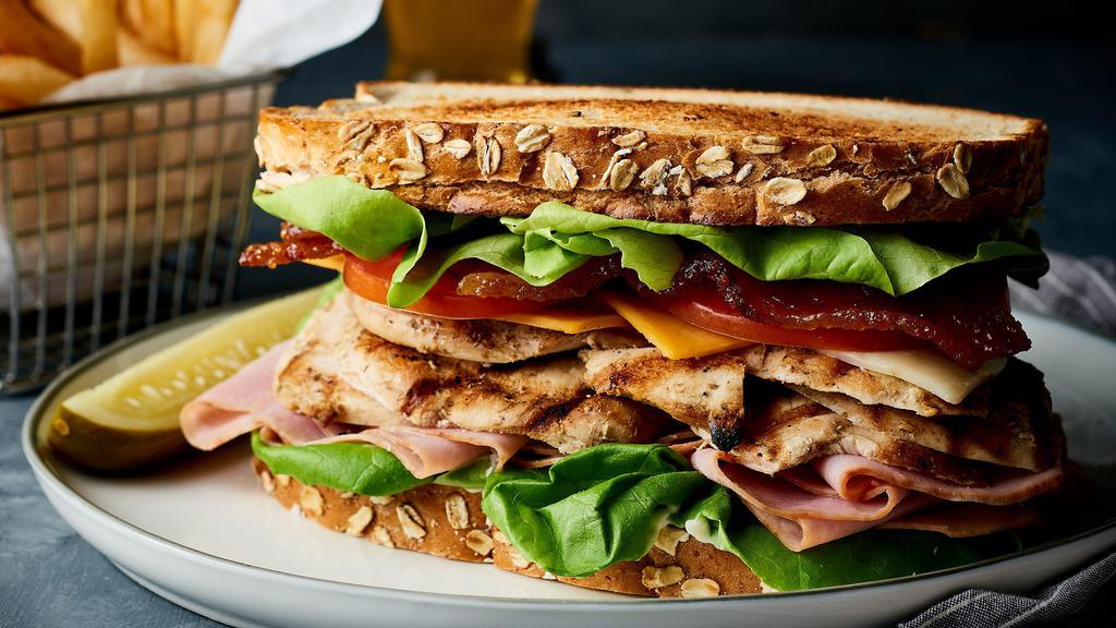 Club Sandwich · sliced chicken breast, classic Virginia cured ham, our signature Tavern apple-wood smoked bacon, Cheddar, and Monterey Jack cheeses, lettuce, tomatoes, mayonnaise, multi-grain bread.