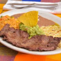 Carne Tampiqueña · Flank Steak grilled with cheese enchilada. Served with a side of guacamole, rice & refried b...