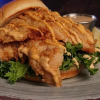 Fried Grouper Filet Sandwich · served with lettuce, chili-lime crema sauce, lemon, on a toasted brioche bun