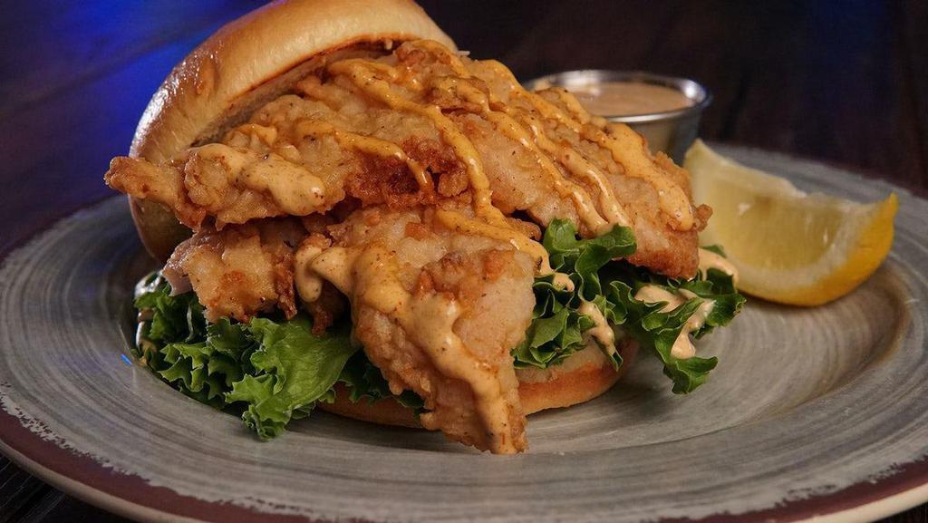 Fried Grouper Filet Sandwich · served with lettuce, chili-lime crema sauce, lemon, on a toasted brioche bun