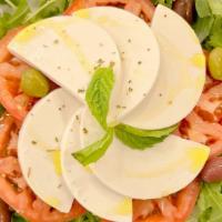 Vegan Caprese Salad · Tomato, arugula, vegan mozzarella cheese, olive oil, green and black olives, and oregano.