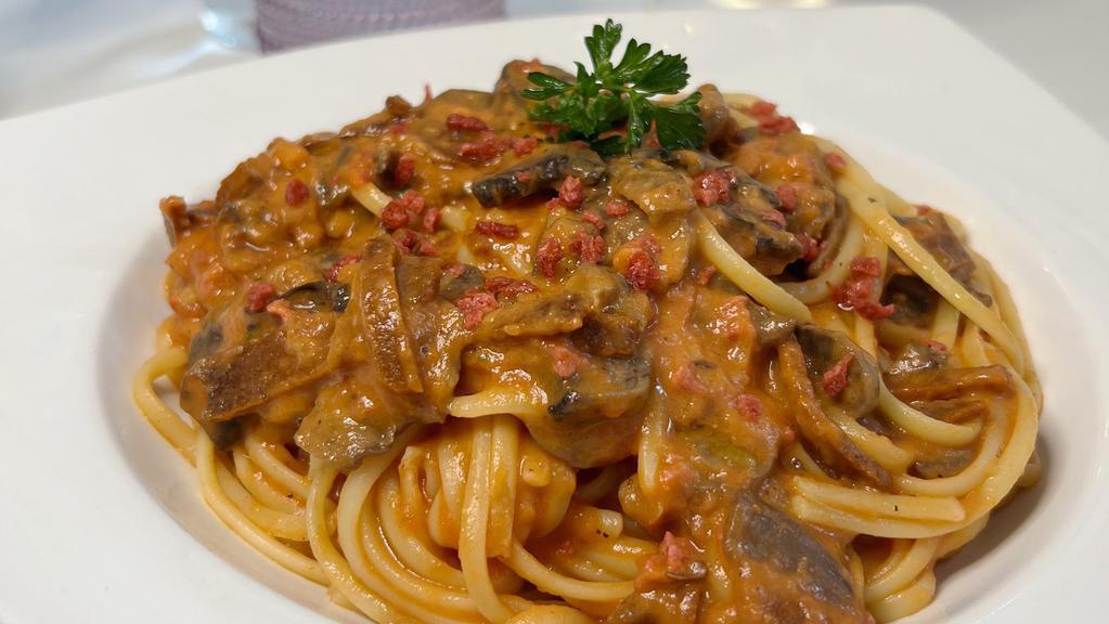 Vegan Linguine Amor Di Pasta · Linguine pasta with vegan pink vodka sauce, vegan bacon, and mushrooms.