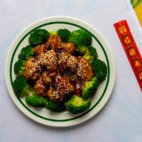 Sesame Chicken · Chunks of crispy chicken in brown sauce with sesame seeds on top.