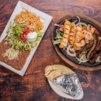 Texas Fajitas · Grilled skirt steak, chicken and shrimp sizzling hot, on a bed of bell peppers and onions. S...