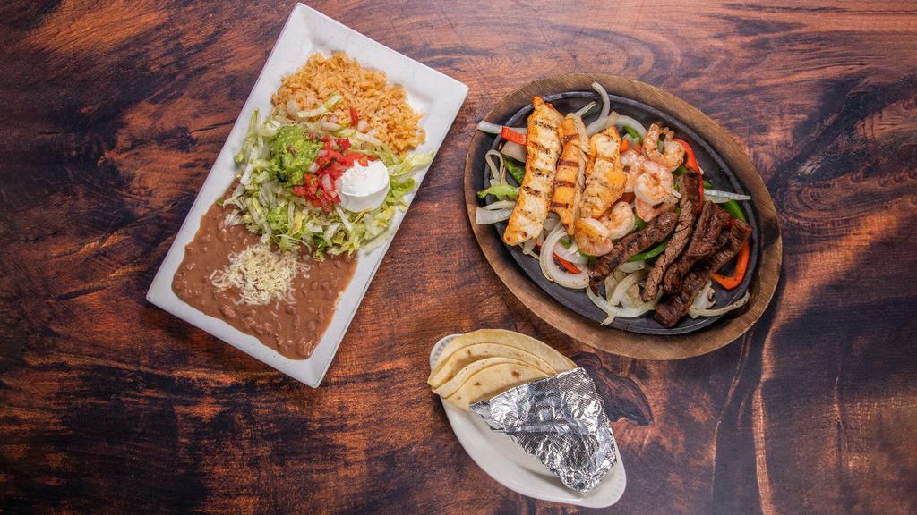 Texas Fajitas · Grilled skirt steak, chicken and shrimp sizzling hot, on a bed of bell peppers and onions. Served with Mexican rice, Mexi-beans, lettuce, pico de gallo, guacamole and crema. Choice of warm flour or corn tortillas.
