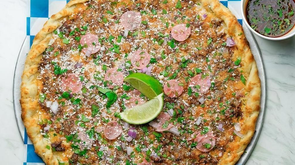 Birria Taco Pizza · Traditional Mexican meat stew made with ancho, guajillo, chile de árbol, a blend of spices then topped with Cotija, onion, a blend of cheeses, cilantro, pickled radish over our house dough and served with a side of consomé.