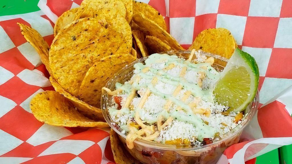 Street Corn · Grilled Golden Corn, Green and Red Peppers. Topped with Cotija Cheese, homemade Garlic Cilantro and a Smokey Chipotle Cream Sauce. Served with Tortilla Chips