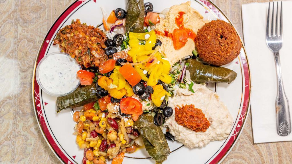 Mediterranean Platter · A sampler plate consisting of hummus, babaganush, tabouli, Mediterranean salad, dolmas, ezme, three bean salad, a falafel and choice of either fruit or pasta salad. Served with pita bread and a side of tzaiki.