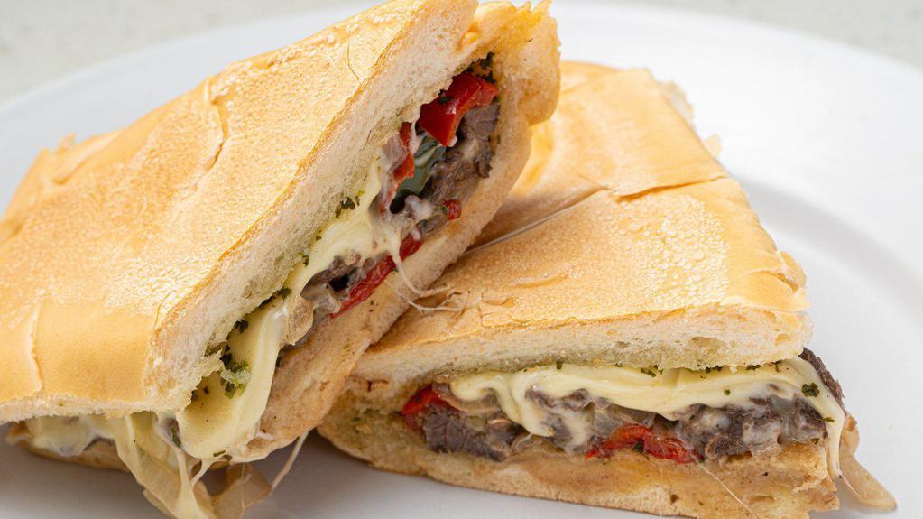Cuban Philly Sandwich · Thin slices of Skirt Steak, grilled onions & peppers, melted Swiss cheese topped with Chimichurri Sauce on toasted Cuban bread