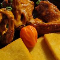 Mango Habanero Dipped Wings  · Pimento Smoked Jerked Chicken wings, dipped in a tangy spicy house made mango habanero sauce...