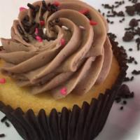 Vanilla & Chocolate Cupcake · Vanilla bean cake, frosted with chocolate buttercream, and garnished with chocolate curls.