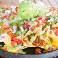 Supreme Tostada Nacho · Seasoned ground beef, cheese blend, yellow queso, refried beans, pico de gallo, fried jalape...