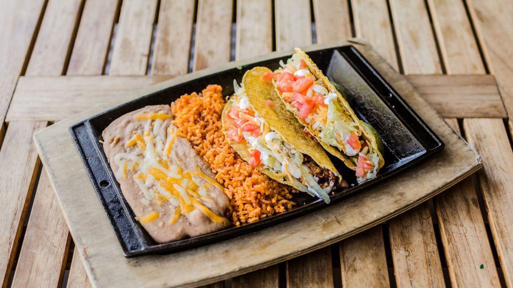 American Tacos · Soft or crunchy tortillas filled with seasoned ground beef, Cheddar & Jack cheese, shredded lettuce, tomatoes & sour cream. Served with Mexican rice and refried beans.
