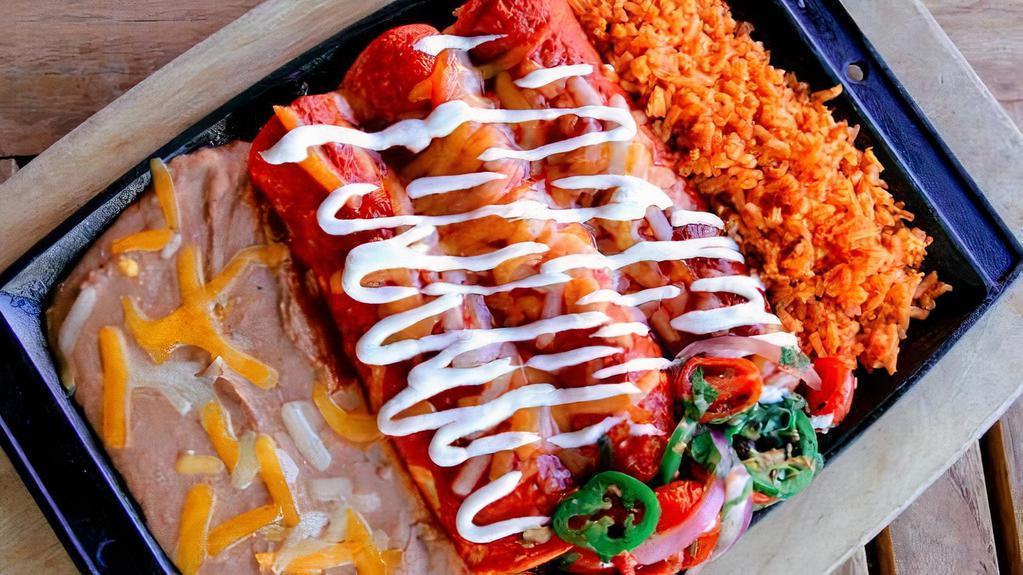 Ultimate Enchilada Combo · Seasoned ground beef, chicken breast and pork carnitas wrapped up in three thick corn tortillas smothered in red or green enchilada sauce. Served with cherry tomato pico de gallo, Mexican rice & refried beans.