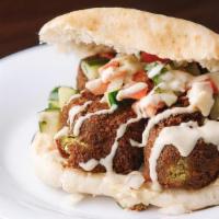 Falafel In The Pita · Crispy falafel balls with hummus, tahini & Israeli salad served in a warm pita.