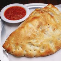 Traditional Cheese Calzone · Pizza dough pocket filled with seasoned ricotta and mozzarella, served with a side of marina...