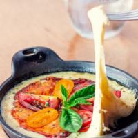 Provoleta Argentina · Melted aged provolone cheese toped with tomato and oregano