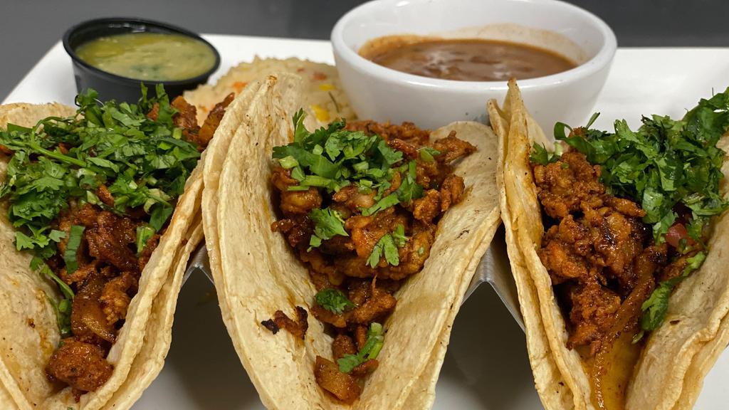 Tacos Al Pastor · Three pastor tacos stuffed with grilled pineapple, fresh cilantro and onions. Served with rice, charro beans and tomatillo sauce. Choice of flour or corn tortillas.