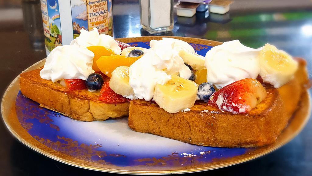 French Toast With Banana And Strawberry · Sourdough bread dipped in a rich egg batter, served golden brown, lightly dusted with powdered sugar and served with whipped butter and hot syrup. Top with Banana, Strawberry and Blueberry.