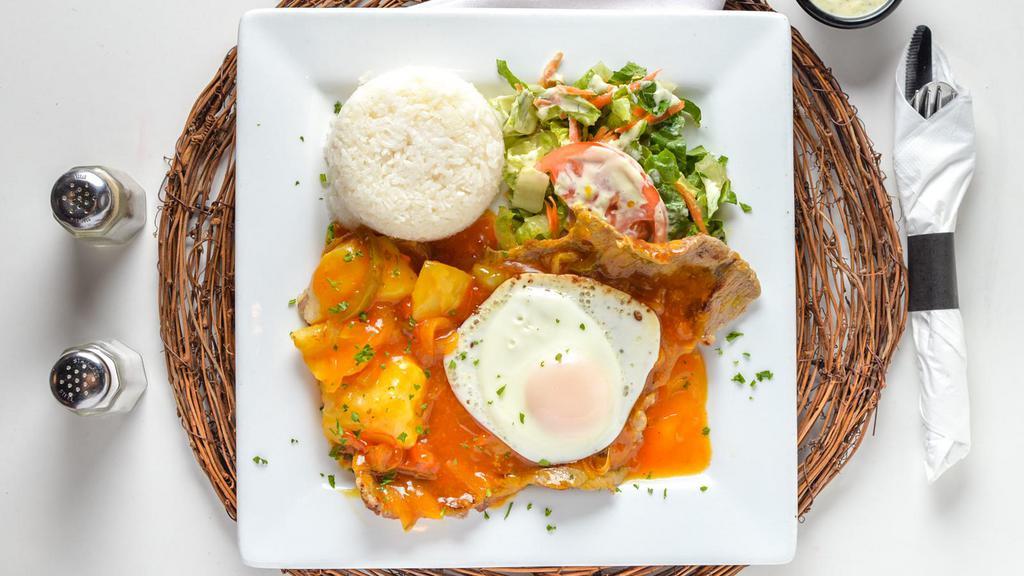 Bistec A Caballo · Steak in our creole sauce with egg on top, served with rice, cassava, potatoes, and salad.