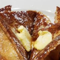 French Toast · Made with fresh baked challah bread served with butter and syrup.