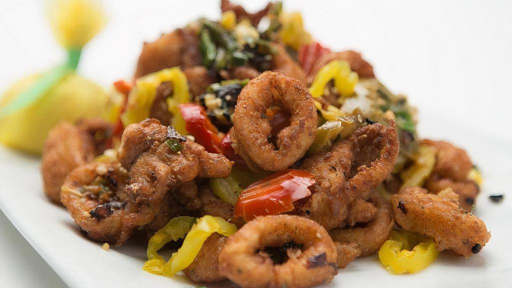 Cherry Pepper Calamari · Squid lightly breaded in seasoned breadcrumbs, flash fried and tossed with sautéed banana peppers, cherry peppers, diced yellow onions and green onions in a homemade garlic butter.