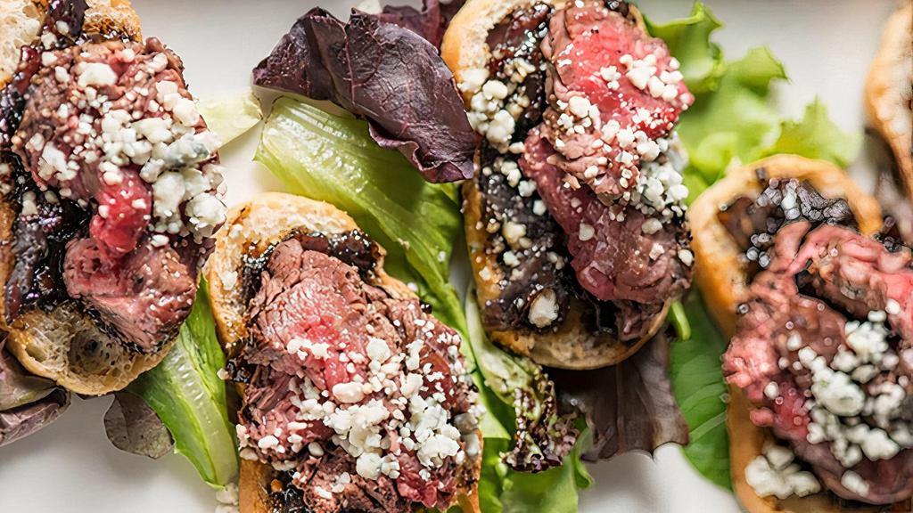 Beef & Bleu* · Six house made crostinis, topped with bacon marmalade, sliced filet and crumbled bleu cheese over a bed of mixed greens.