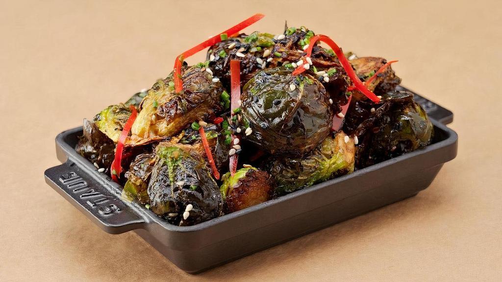 Sweet Sriracha Brussels Sprouts · Fried baby Brussels sprouts, tossed in a sriracha caramel vinaigrette and red bell peppers, garnished with toasted sesame seeds and chives.