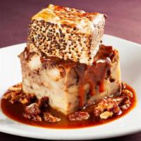 Rocky Road Bread Pudding · Traditional bread pudding infused with chocolate chips and served over caramel sauce and top...