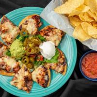 Acapulco Chicken Nachos · Grilled chicken and refried black beans topped with raspberry chipotle sauce, diced pineappl...