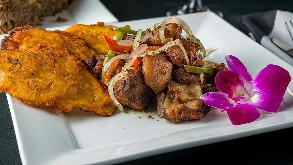 Griot · Marinated fried pork chunks topped with peppers and onions, mild or spicy. Served with one side.
