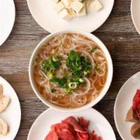 Pho · Vietnamese Noodle Soup made with beef bone broth served with green onions, onions, and cilan...